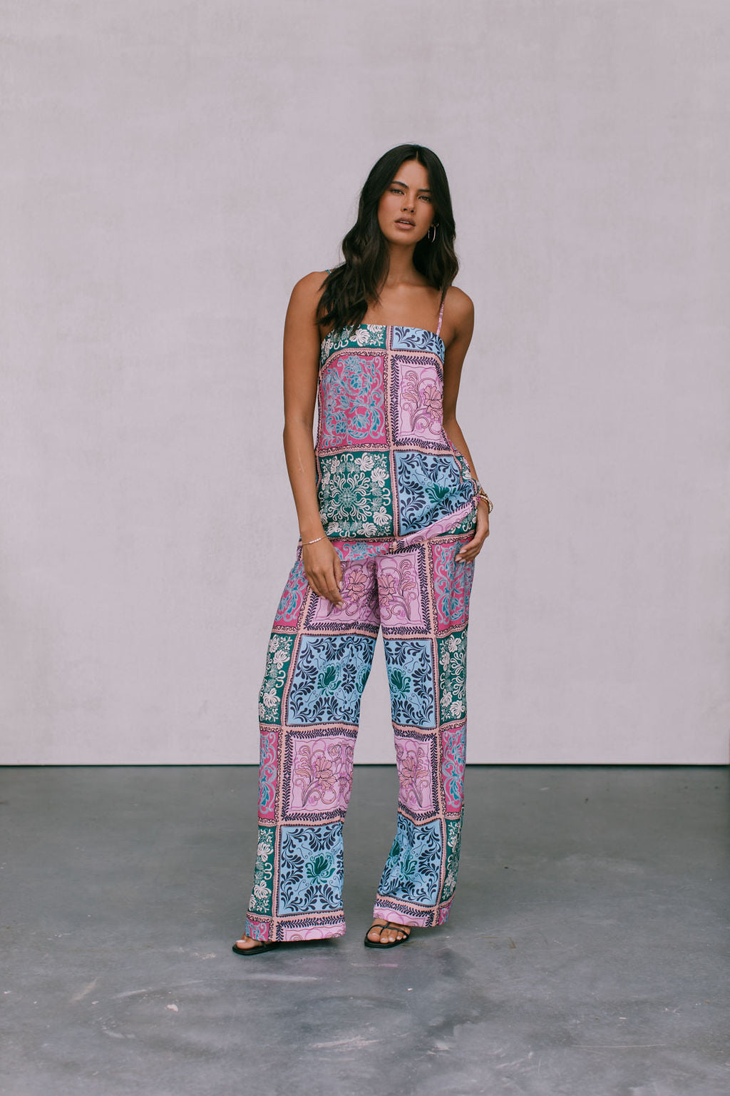 A woman wearing a paisley tile print singlet top in multicolor, with a straight neckline and adjustable straps.