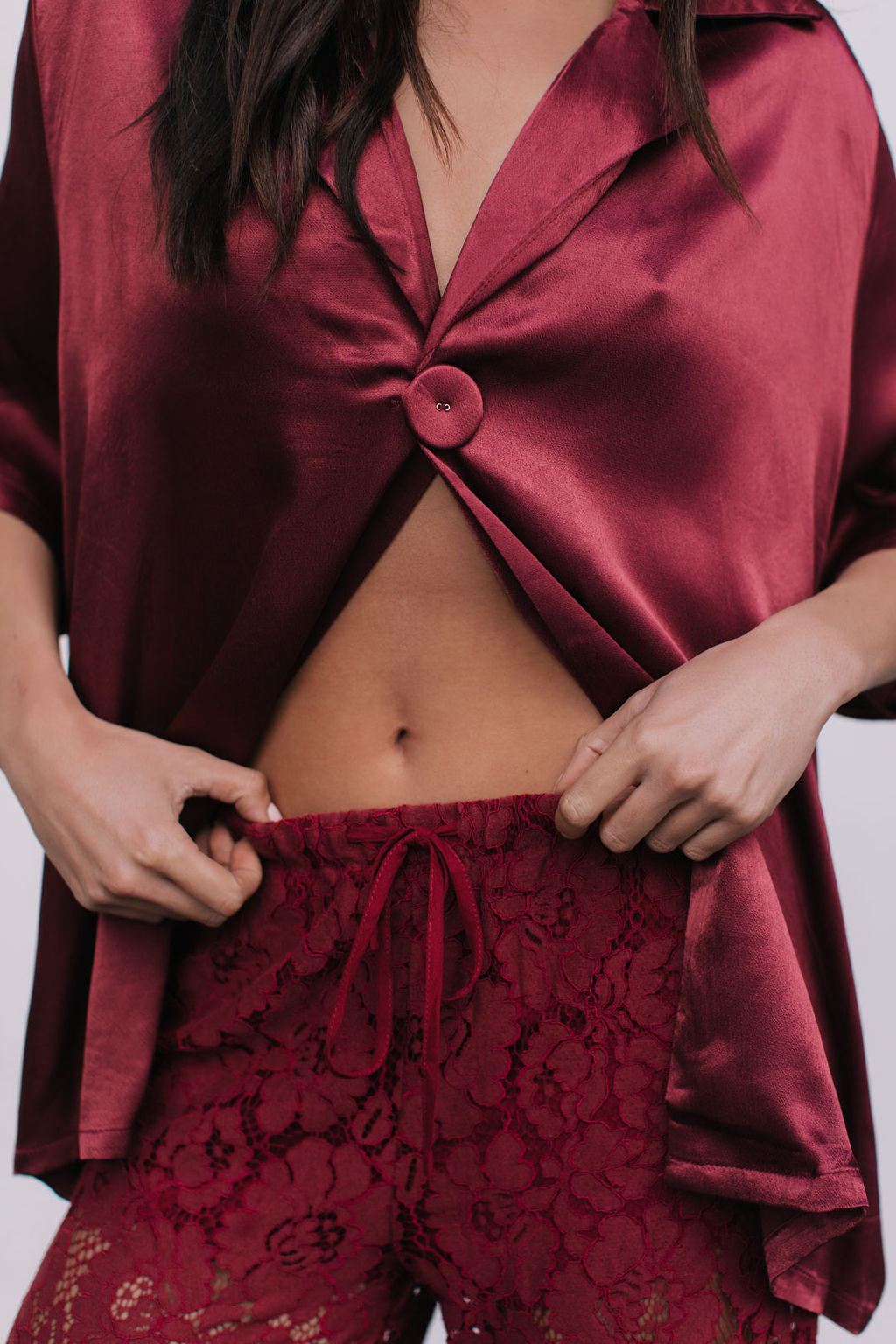 Burgundy satin top and lace pants on a white background