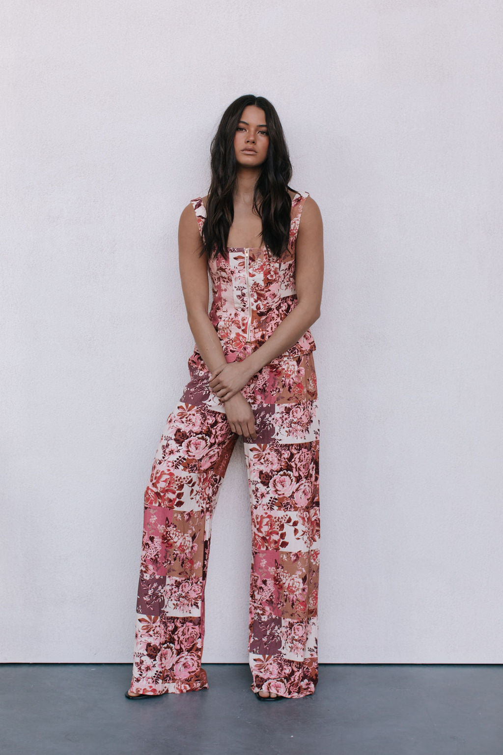 Woman wearing a floral jumpsuit against a white background
