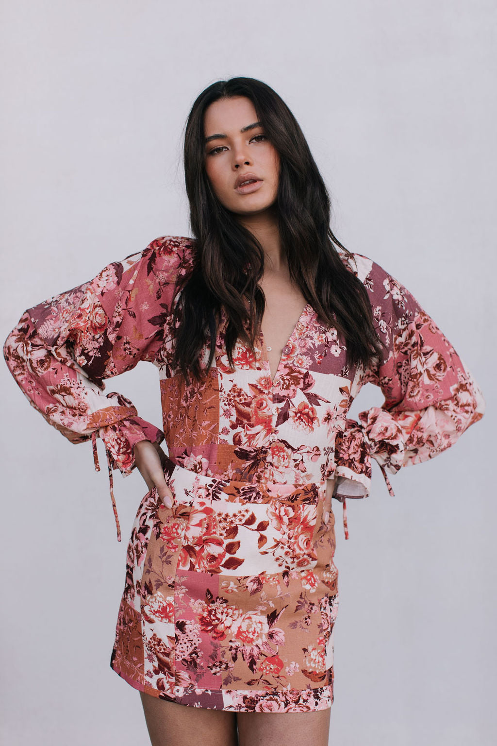 Woman wearing a floral dress against a plain background
