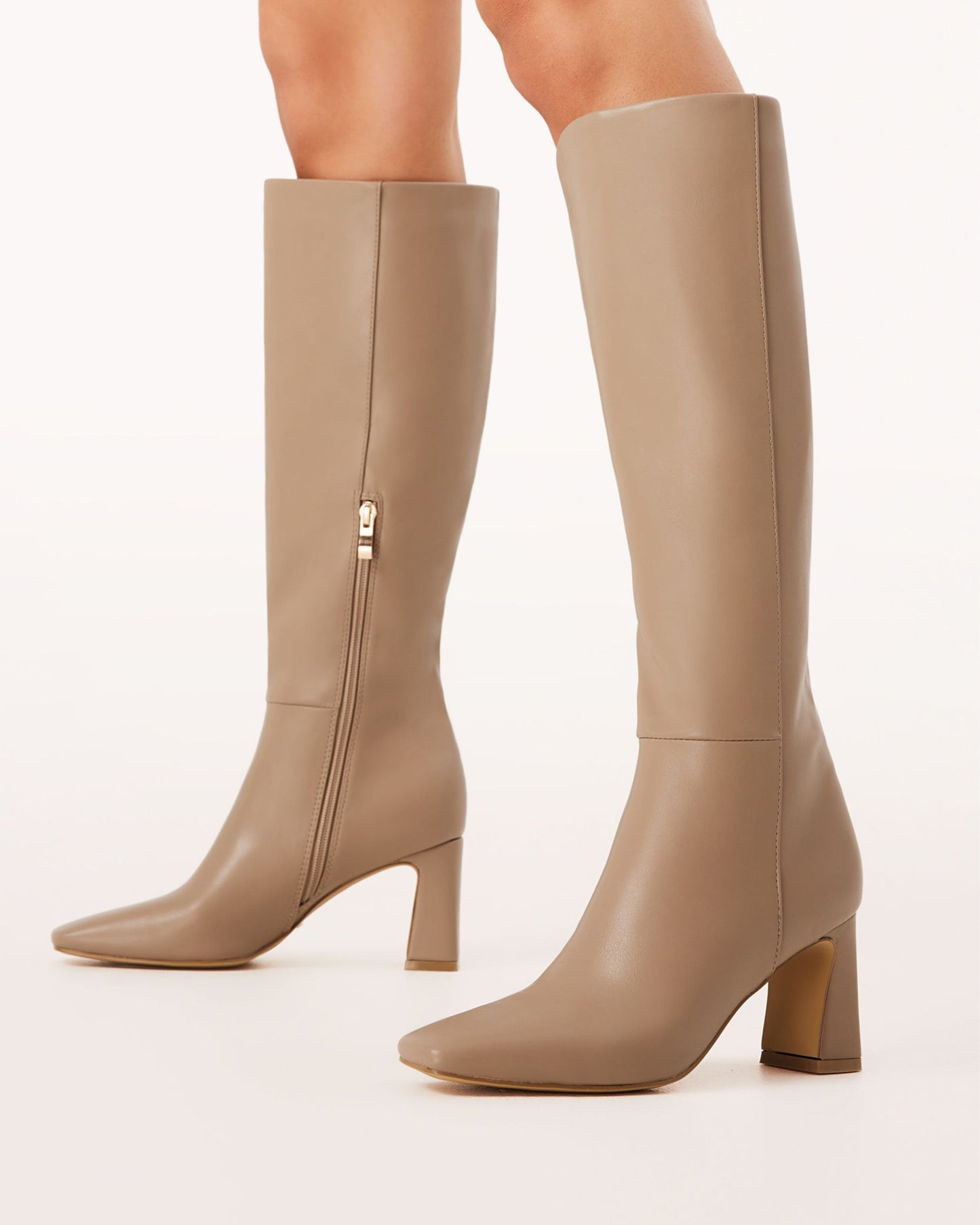A pair of knee-high boots in a truffle brown tone with a block heel and square toe.