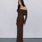 Woman wearing a brown off-shoulder dress against a plain background