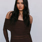 Woman wearing a brown off-shoulder dress against a plain background