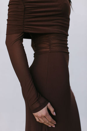 Brown dress with long sleeves and a fitted waist on a white background