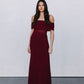 Woman wearing a burgundy off-shoulder dress against a plain background