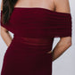 Burgundy off-shoulder dress worn by a person on a plain background