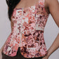 Woman wearing a floral patterned top against a plain background
