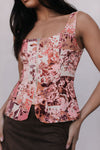 Woman wearing a floral patterned top against a plain background