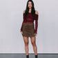 Woman wearing a burgundy off-shoulder top and brown skirt against a plain background