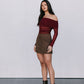 Woman wearing a burgundy off-shoulder top and brown skirt with black boots against a white background