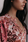 Close-up of a woman wearing a floral dress with a blurred background