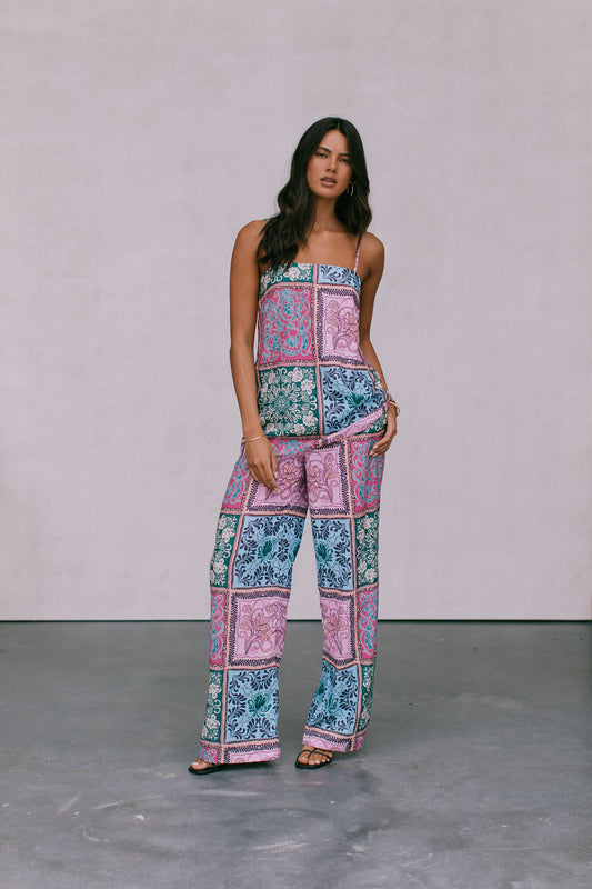 A woman wearing a paisley tile print singlet top in multicolor, with a straight neckline and adjustable straps.