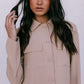 Woman wearing a beige suit against a white background