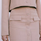 Beige suit jacket and skirt worn by a person on a plain background