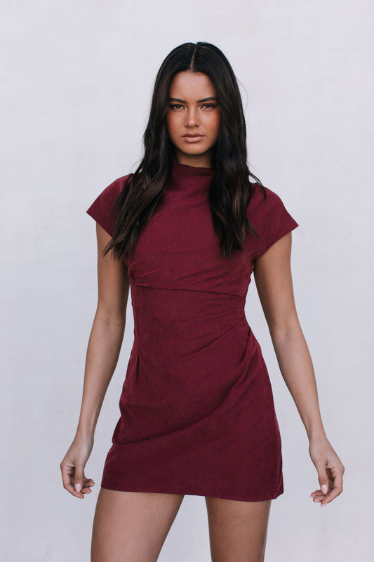 Woman wearing a burgundy dress against a white background