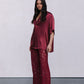 Woman wearing a burgundy set against a plain background