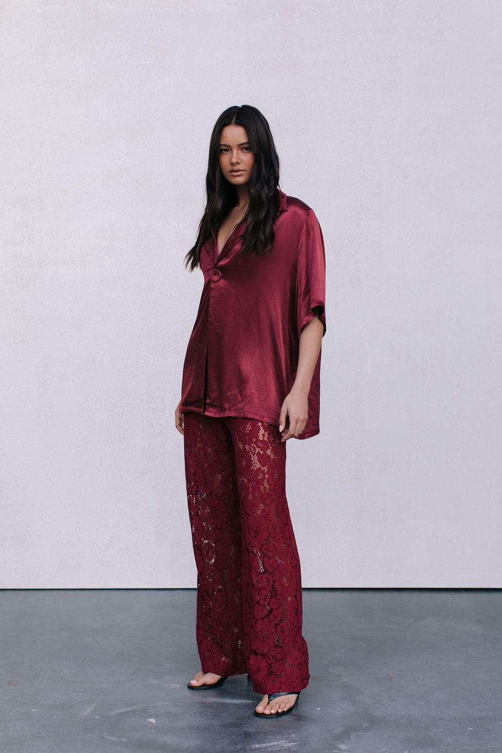 Woman wearing a burgundy set against a plain background