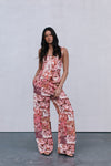 Woman wearing a floral jumpsuit against a plain background