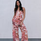 Woman wearing a floral jumpsuit against a plain background
