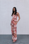 Woman wearing a floral jumpsuit against a plain background