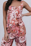 Person wearing a floral jumpsuit with a plain background