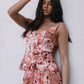 Woman wearing a floral dress against a plain background