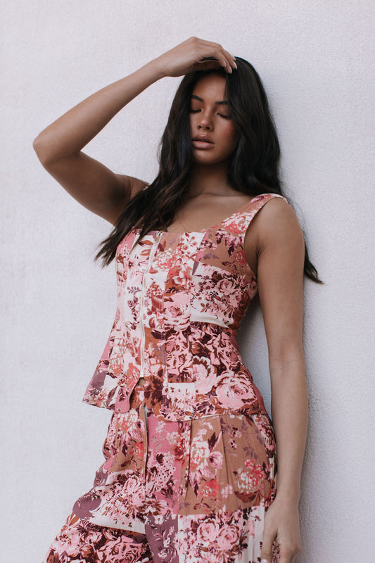 Woman wearing a floral dress against a plain background