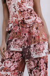 Floral patterned outfit with a top and pants on a plain background
