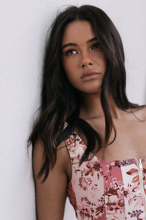 Woman wearing a floral dress against a white background