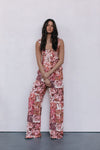 Woman wearing a floral jumpsuit against a white background