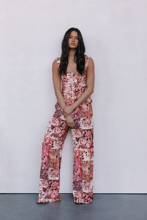 Woman wearing a floral jumpsuit against a white background