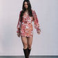 Woman wearing a floral dress and brown boots against a white background
