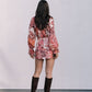 Person wearing a floral dress and brown knee-high boots against a plain background