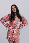 Woman wearing a floral dress against a plain background