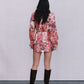 Person wearing a floral dress and knee-high boots against a plain background