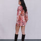 Woman wearing a floral dress and knee-high boots against a plain background