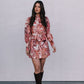 Woman wearing a floral dress and brown boots against a plain background