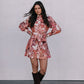 Woman wearing a floral dress and brown boots against a plain background