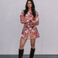 Woman wearing a floral dress and knee-high boots against a plain background