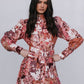 Woman wearing a floral dress against a plain background