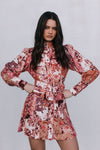 Woman wearing a floral dress against a plain background