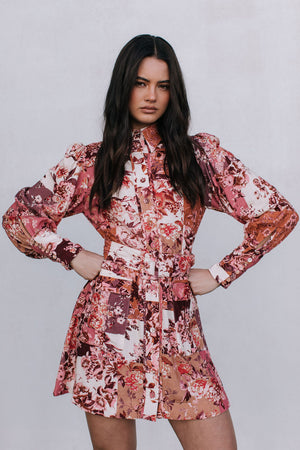 Woman wearing a floral dress against a plain background