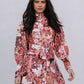 Woman wearing a floral dress against a plain background