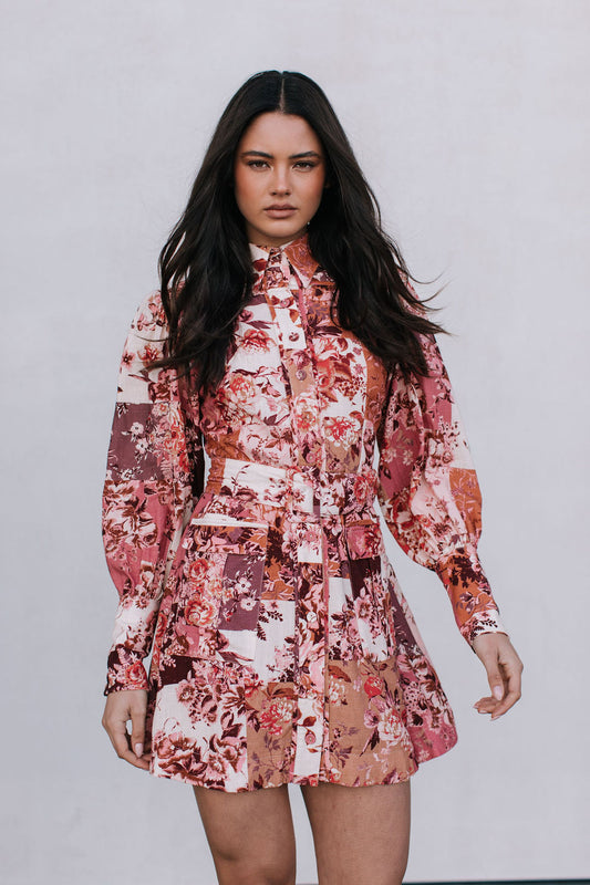 Woman wearing a floral dress against a plain background