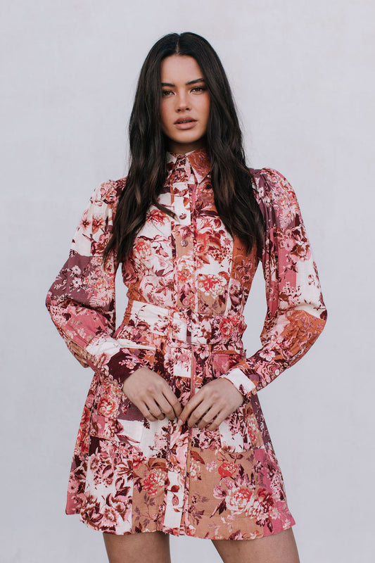 Woman wearing a floral dress with a plain background