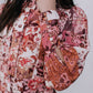 Person wearing a floral dress with long sleeves and a white background