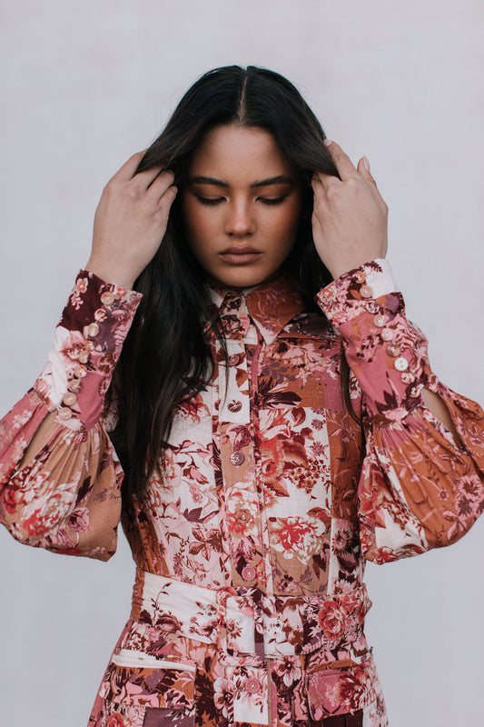 Woman wearing a floral patterned dress against a plain background