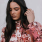 Woman wearing a floral blouse against a plain background