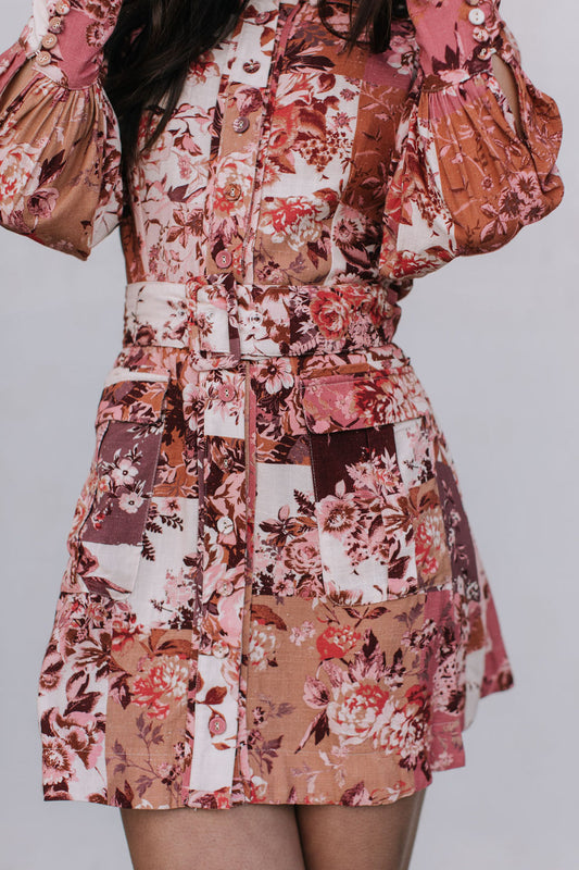 Floral patterned dress with puffed sleeves on a plain background