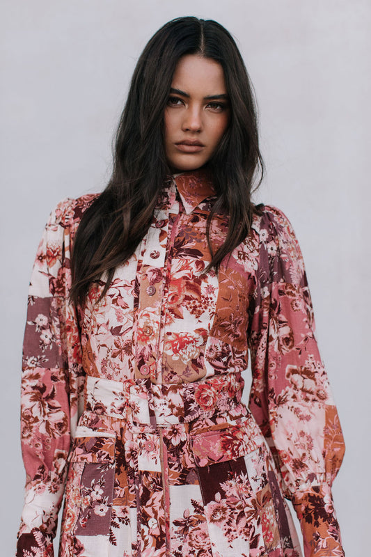 Woman wearing a floral patterned outfit against a plain background